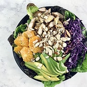 Arranged and dressed Harvest Chicken Salad in a black bowl.