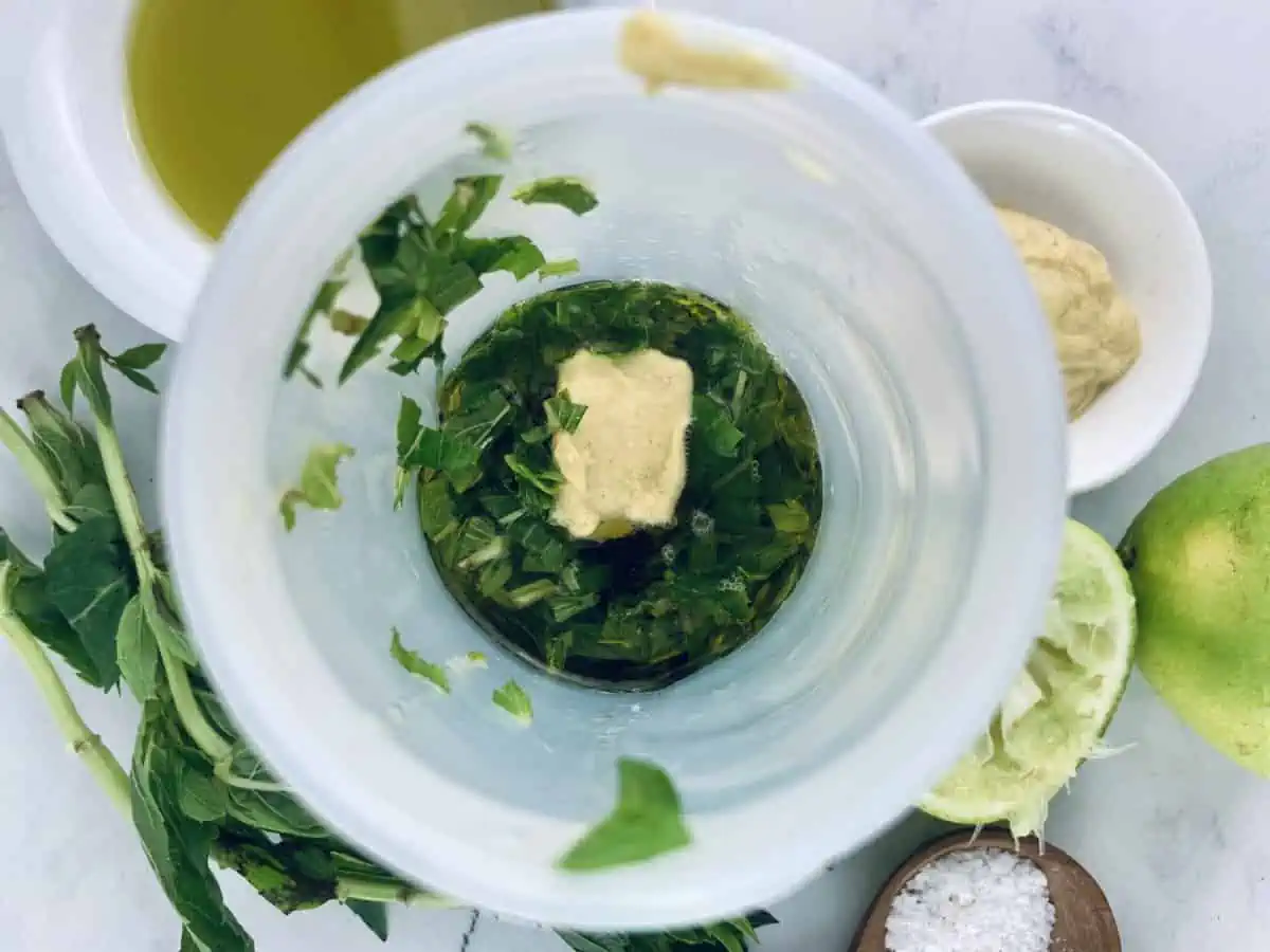 Mint Lime Dressing ingredients in a blender with other ingredients scattered around.