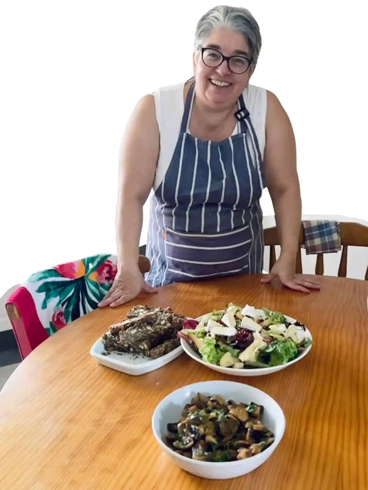 A photo of Anastasia Papapetros in front of a table with salads.