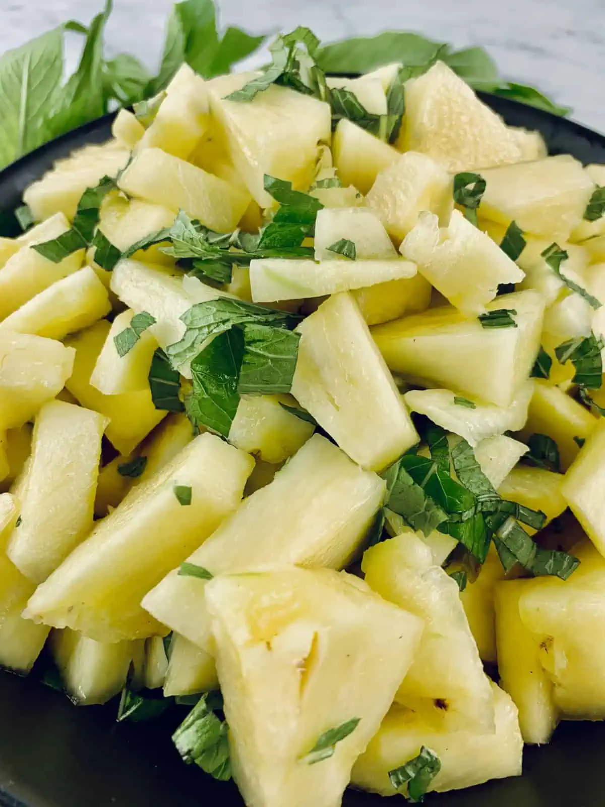 A close-up of fresh pineapple and mint salad.
