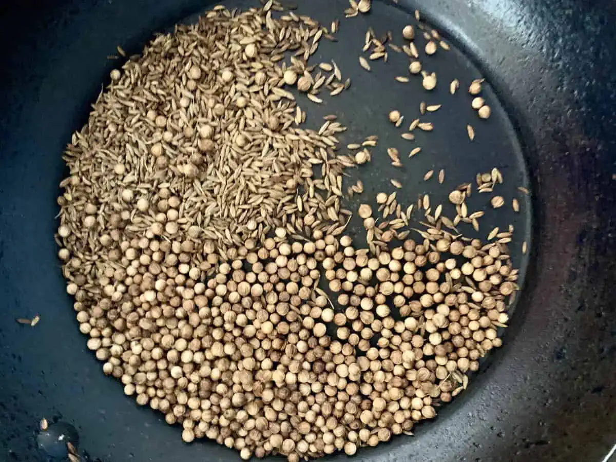 Whole spices being roasted in a frypan.
